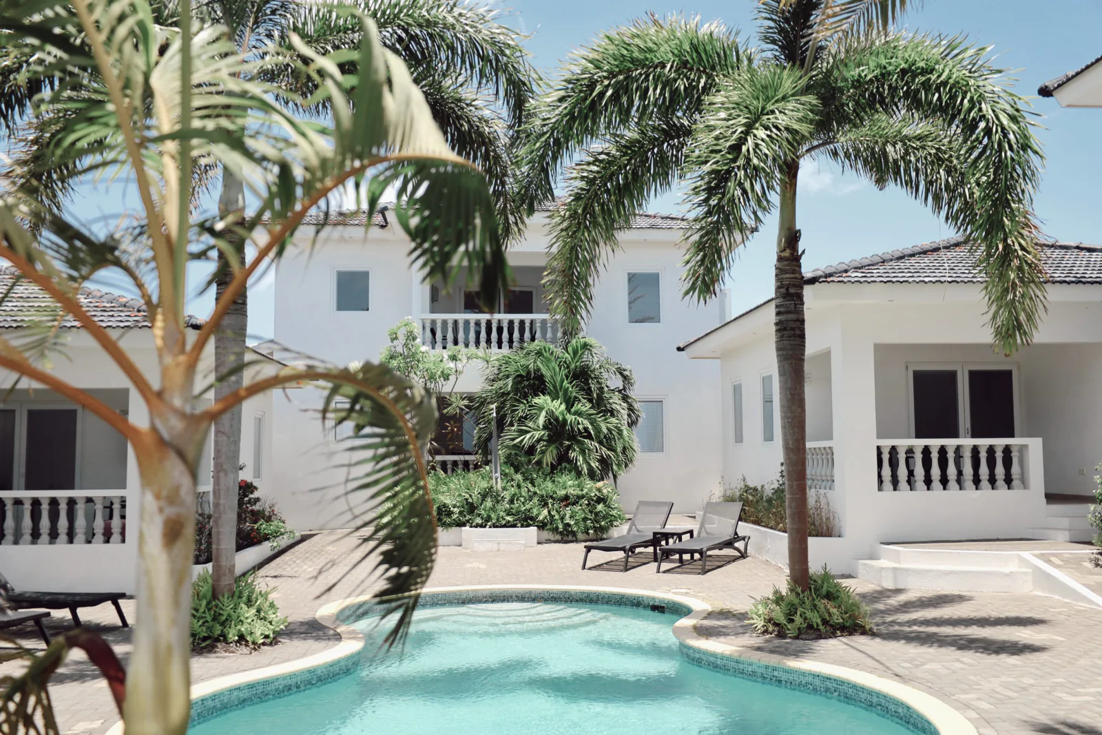 De witte appartementen en palmen van Palm Crest Curaçao